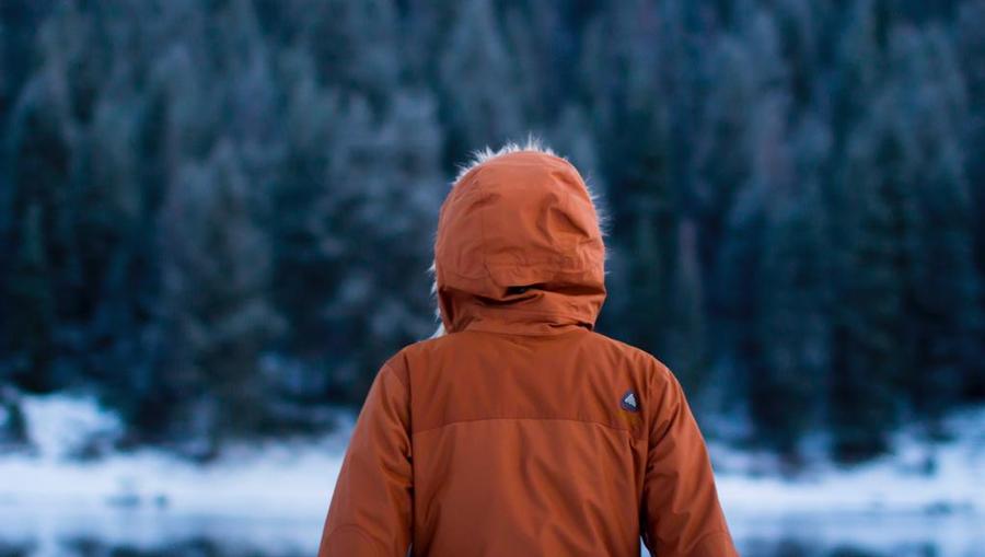 A traveler wearing a heavy jacket in a cold setting.