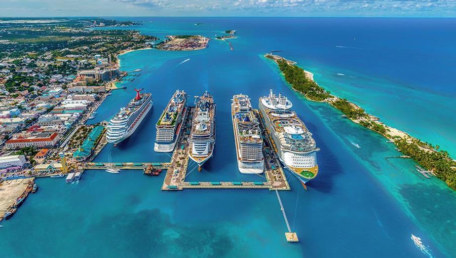 Cruise ships docked in the bright blue waters of the Bahamas.
