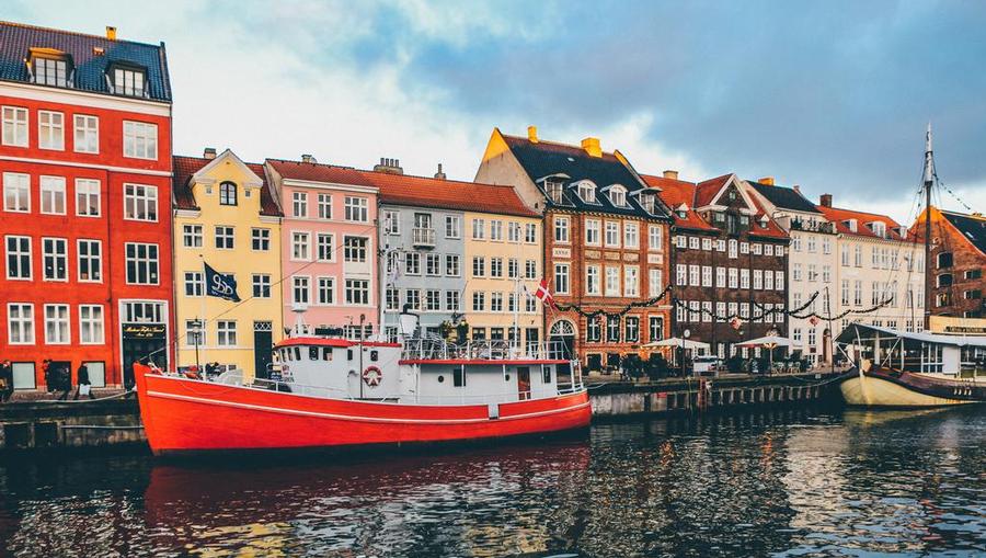 A view of a canal, colorful buildings and boats in Copenhagen, Denmark. 
