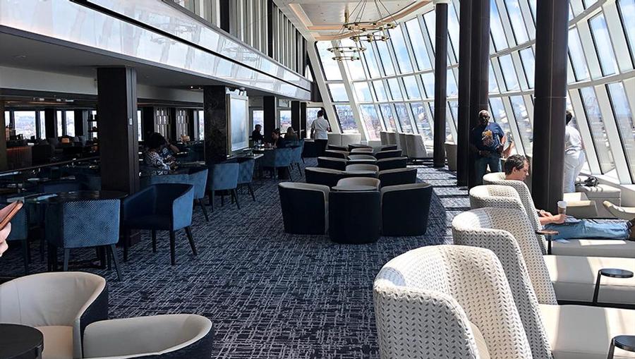 A view of the Observation Lounge onboard Norwegian Joy that features panoramic aft views and lounge chairs.