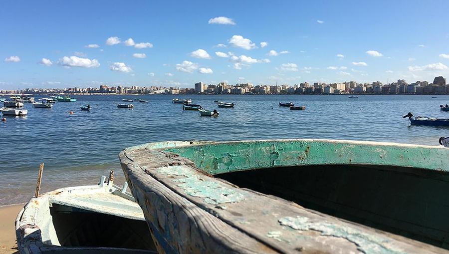 An ocean-front view of the water and boats in Alexandria, Egypt.