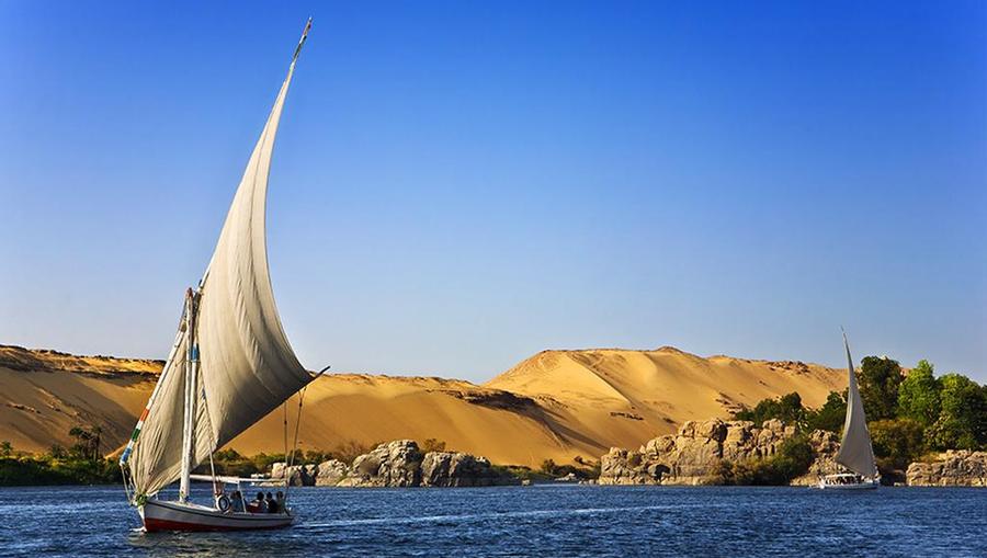 A scenic view of the Nile River with traditional Egyptian sail boats.