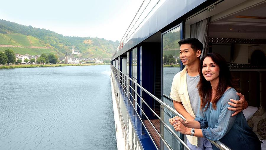 A couple looking outside of their balcony from an AmaWaterways ship.