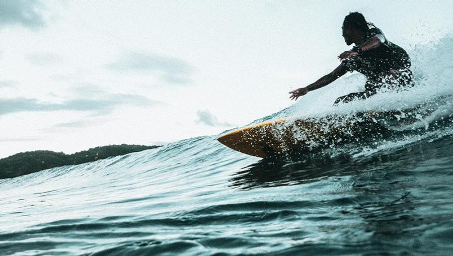 A surfer rides a wave in Maui, Hawaii.