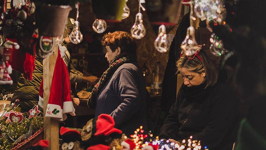Two women shopping in the Barcelona holiday markets during Christmas time. 