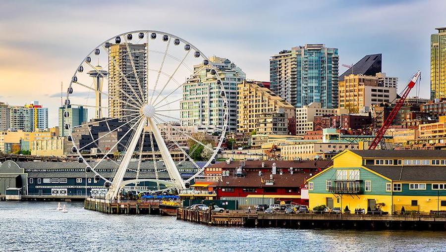A view of the bayside Ferris wheel and surrounding buildings and cityscape of Seattle, Washington.