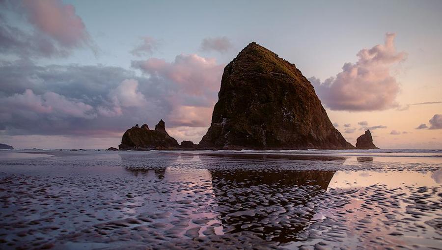 Beautiful Portland, Oregon coastline with large rock emerging from Pacific Ocean.